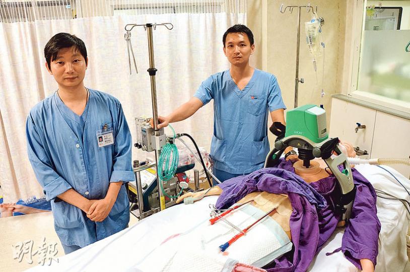 冼維正醫生（右）說，E-CPR可讓急症室和成人深切治療部醫生同步設置儀器，愈早運作人工心肺，愈可減低病人其他器官因心跳停頓的受損程度。旁為魏振威醫生（左），以模型示範該療法。（袁樂婷攝）