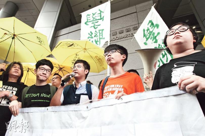 學聯秘書長羅冠聰（左起）、前秘書長周永康、學民思潮召集人黃之鋒昨日就去年9月26日闖入公民廣場一事，到警署接受調查並被起訴。（李紹昌攝）