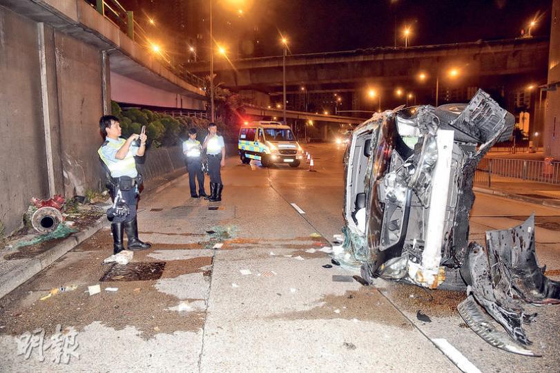 四驅車高速失控撼向路邊橋躉及消防栓後連翻多個筋斗，再反彈回路翻側停下，車頭毁如廢鐵，司機重傷不治，事後警員封鎖現場調查。（蔡方山攝）