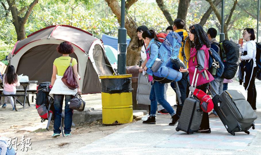 10多名內地旅客自攜營具，昨日跟隨領隊浩浩蕩蕩到大嶼山貝澳營地草地紮營，但拖拉旅行篋的聲音與寧靜的營地格格不入。（黃志東攝）內地團友手持中國護照，一邊填寫申請營地的表格，再交予領隊處理。（李詠珊攝）同團內地旅客將帳篷放在一起（右方4個）以便互相照應。他們執拾行李後以輕便行裝繼續行程，餘下較大型行李放在帳篷內，有旅客表示不擔心，相信營地十分安全。（黃志東攝）