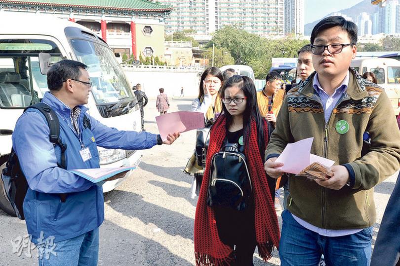 據本報記者觀察，採訪期間黃大仙祠外大部分導遊都無佩戴導遊證，並無旅議會人員上前警告或勸喻，但見有旅議會人員在場向旅客派發宣傳單張（圖）。（楊柏賢攝）