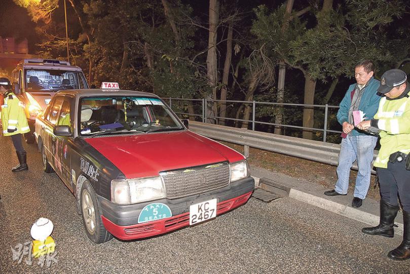 的士撞傷設路障的交通警員，司機（右二）涉嫌危險駕駛被捕，的士亦被拖走檢驗。（蔡方山攝）
