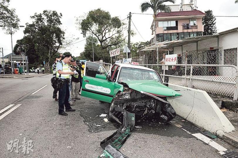 的士沿斜路駛出大路時高速直撼路邊石壆，車頭嚴重損毁，車上司機及乘客一死兩傷。（賴俊傑攝）