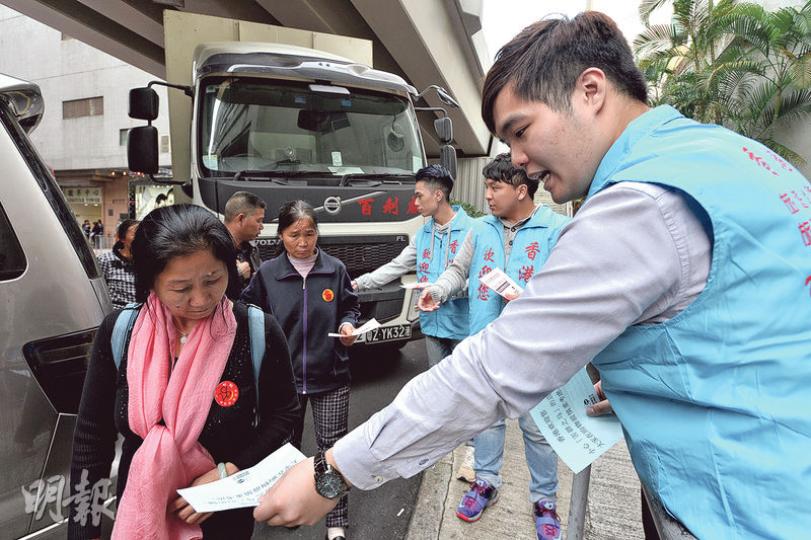 與旅議會打對台的旅遊從業員聯會，連日派員到一些參與旅議會登記店舖計劃的商舖外派發單張，呼籲旅客「精明購物」。圖為身穿該會藍色背心的人在紅磡民裕街遊客購物區派傳單。（楊柏賢攝）部分單張以簡體字呼籲旅客小心「害群之馬」。（楊柏賢攝）