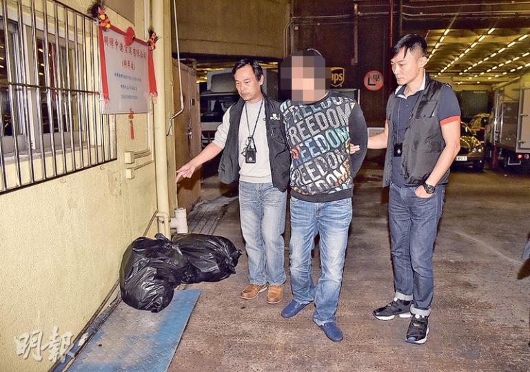男子（右）涉嫌上周在九龍灣大業街一個停車場棍打及淋漂白水襲擊唐狗，昨凌晨被警方拘捕，押返現場調查。（蔡方山攝）