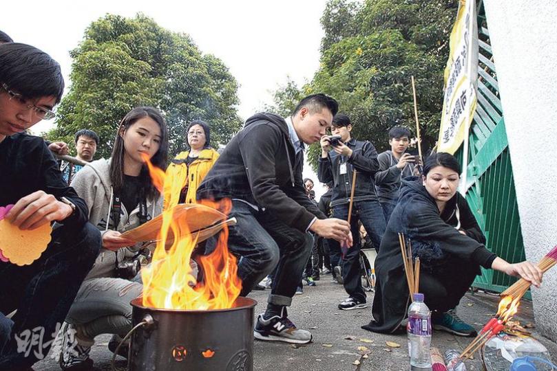 一班本土派噚日去培僑中學燒衣紙抗議，話要致祭前日發現行山意外身亡嘅本土派成員蔡維益。（李紹昌攝）