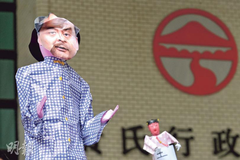 嶺大昨召開校董會，數名校友關注組成員帶同印有該校校監、特首梁振英相片的紙紮公仔到場外示威，諷刺有很多「傀儡校董」為政權服務。（楊柏賢攝）嶺大校友關注組昨試圖向與會校董遞信，要求設專責小組檢討特首必然任校監制及校董會組成等。關注組批評校方保安嚴密，向校董何君堯（左一）遞信時，多名保安護送他。（楊柏賢攝）