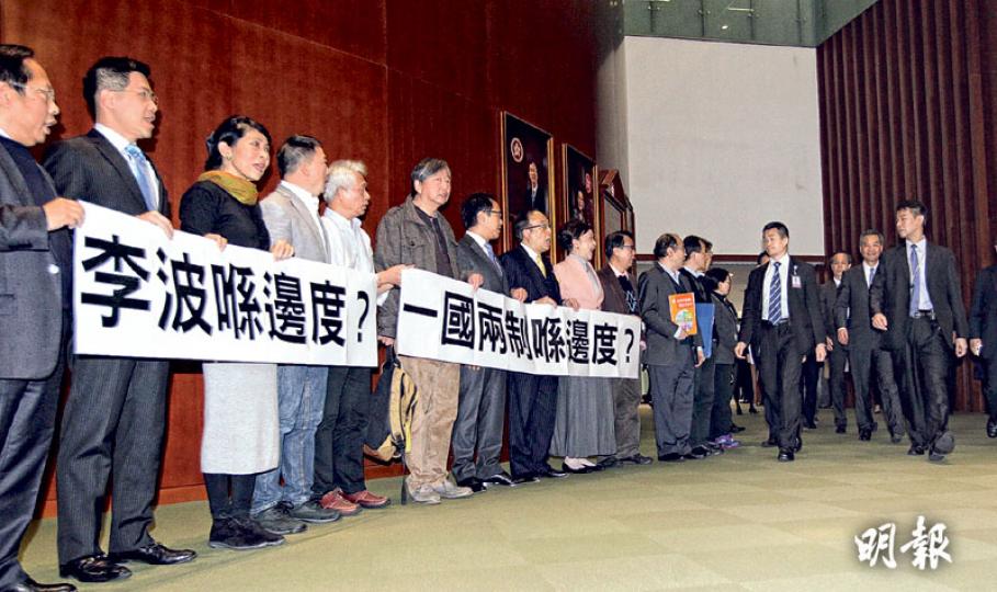 立法會昨晨舉行特首答問大會，會議前多名泛民議員（左列），在會議廳外拉起寫有「李波喺邊度？一國兩制喺邊度？」橫額迎接特首梁振英（右二）。梁步過時沒有理會泛民議員，議員也沒有阻礙梁出席立法會。梁在會上重申，一直有跟進李波事件。（郭慶輝攝）