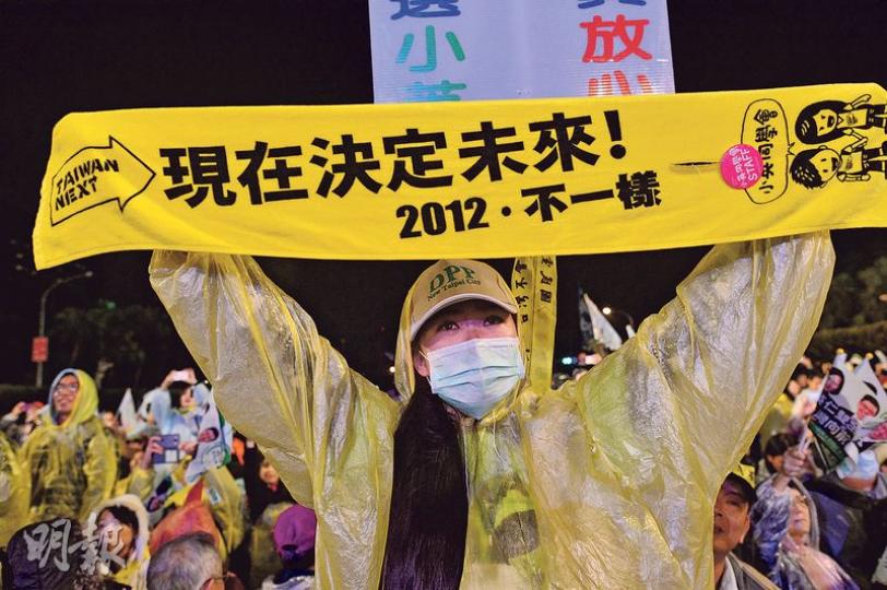 在蔡英文的造勢晚會結束後，有支持者不願離去，圖為一名支持者激動高舉蔡英文2012年競選時的宣傳橫額「現在決定未來」，眼泛淚光。（鄧宗弘攝）