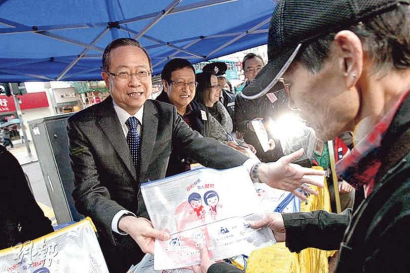 保安局長黎棟國（左）昨在灣仔向市民派發防範罪案的單張和宣傳品，他指已就銅鑼灣書店負責人李波等5人失蹤事件向內地多次查詢，惟至昨日仍未獲回覆。（李紹昌攝）