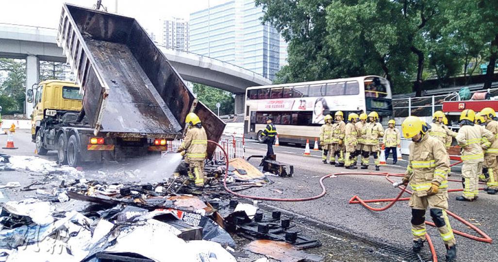 貨車駛出東隧後，司機將起火的廢物卸下馬路，消防到場將火救熄。（林智傑攝）
