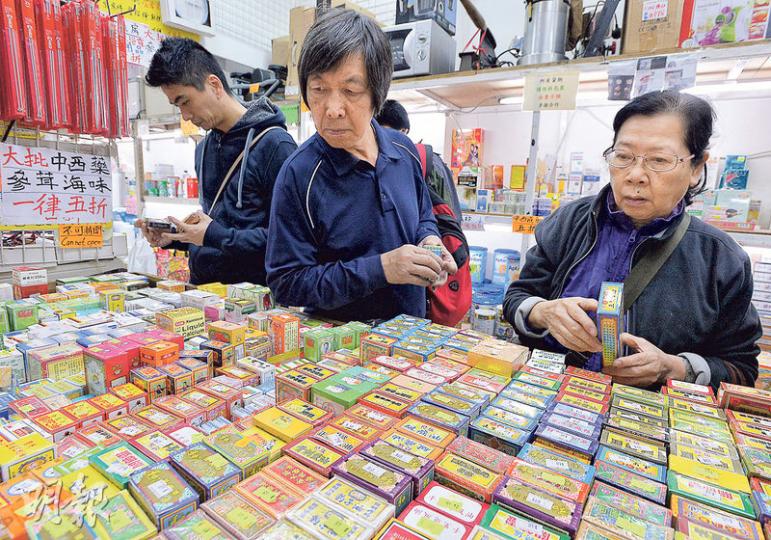 「大福行夜冷」近日買下了兩家藥房的「執笠貨」，店面猶如變成藥房，到處都是奶粉、藥油、保健品等。店東郭文稱定價視乎成功投得的價位。（馮凱鍵攝）郭文40多年前當起「夜冷佬」，「大福行夜冷」是他的心血，每天坐在收銀台前，拿着計算機收銀。他說生意好壞靠「彩數」，重點要對準街坊喜好入貨。（馮凱鍵攝）