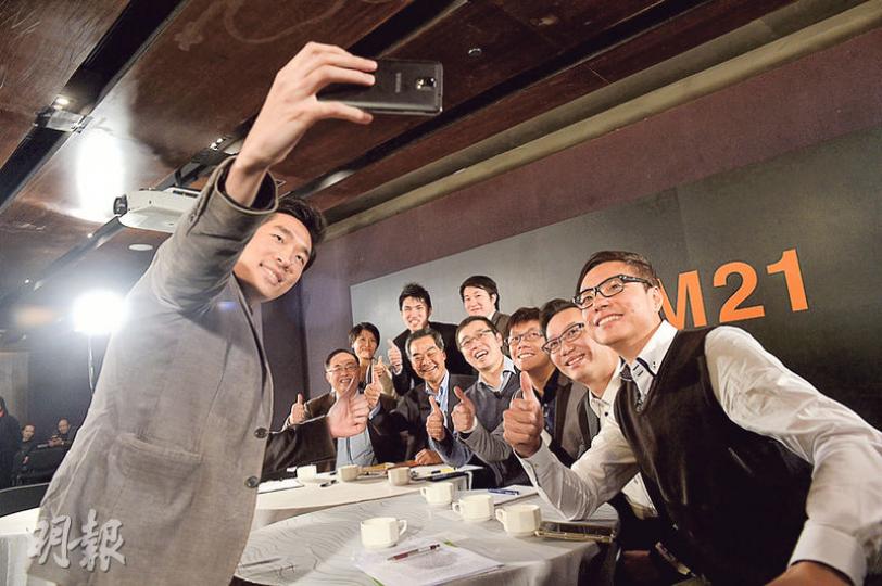 特首梁振英（中排左二）及創科局長楊偉雄（中排左一）昨日出席論壇後，與一眾年輕創科業者自拍留影。當大家隨後用facebook分享相片時，梁振英主動提出「我add你呀」，但梁並非拿出電話，而是用筆抄下對方fb名字，再交由新聞統籌專員馮煒光處理。（鍾林枝攝）