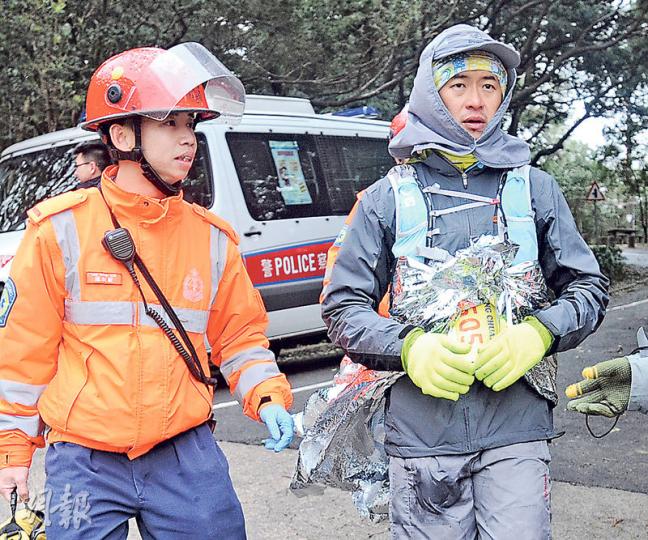 大帽山封閉上山道路期間,陸續有越野長跑參賽者因低溫症不適,披着保暖氈由救護員帶到山腳接受治療。(衛永康攝) 大帽山封閉上山道路期間,陸續有越野長跑參賽者因低溫症不適,披着保暖氈由救護員帶到山腳接受治療。(衛永康攝)
