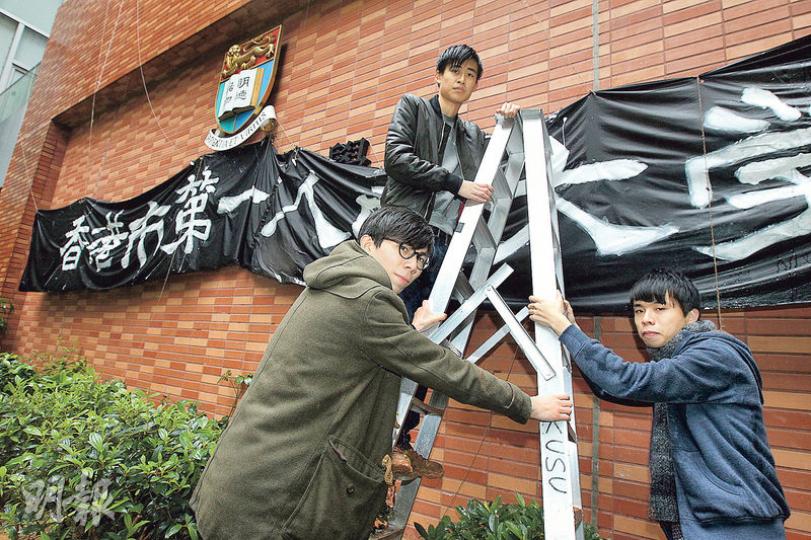 《學苑》前總編輯袁源隆(左起)、社會科學學會前時事秘書楊嘉驃及《學苑》前副總編輯王俊杰等,上周五在校內紅磚牆掛起「香港市第一人民大學」巨型橫額。(李紹昌攝) 《學苑》前總編輯袁源隆(左起)、社會科學學會前時事秘書楊嘉驃及《學苑》前副總編輯王俊杰等,上周五在校內紅磚牆掛起「香港市第一人民大學」巨型橫額。(李紹昌攝)