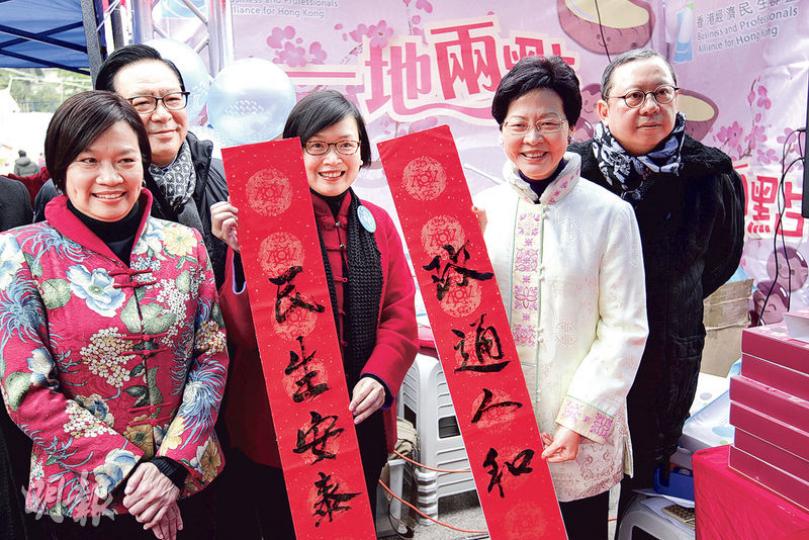 政務長司林鄭月娥(右二)昨日早上表示不會出席民主黨黨慶,但下午出席經民聯花市攤位揭幕時,邀請民政事務局副局長許曉暉(右三)書寫「政通人和」的揮春,寄寓新一年。(郭慶輝攝) 政務長司林鄭月娥(右二)昨日早上表示不會出席民主黨黨慶,但下午出席經民聯花市攤位揭幕時,邀請民政事務局副局長許曉暉(右三)書寫「政通人和」的揮春,寄寓新一年。(郭慶輝攝)