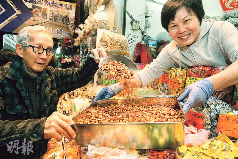 年過八十的吳厚生（左）30年前以花生起家，至今仍堅持天天炒花生，其妻（右）主力打理店面，坦言工作辛苦，但見到顧客吃到自家出品，相當滿足。（李紹昌攝）