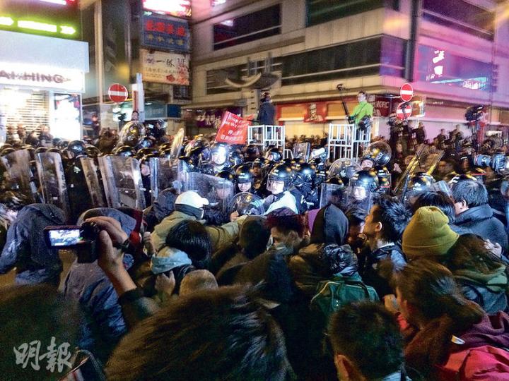 在砵蘭街及山東街交界，一度有大批激進示威者衝擊警方防線。（吳淑義攝）激進示威者在豉油街與花園街交界擊毁一輛的士車窗，圖右方的示威者正試圖點燃的士車胎。（李紹昌攝）