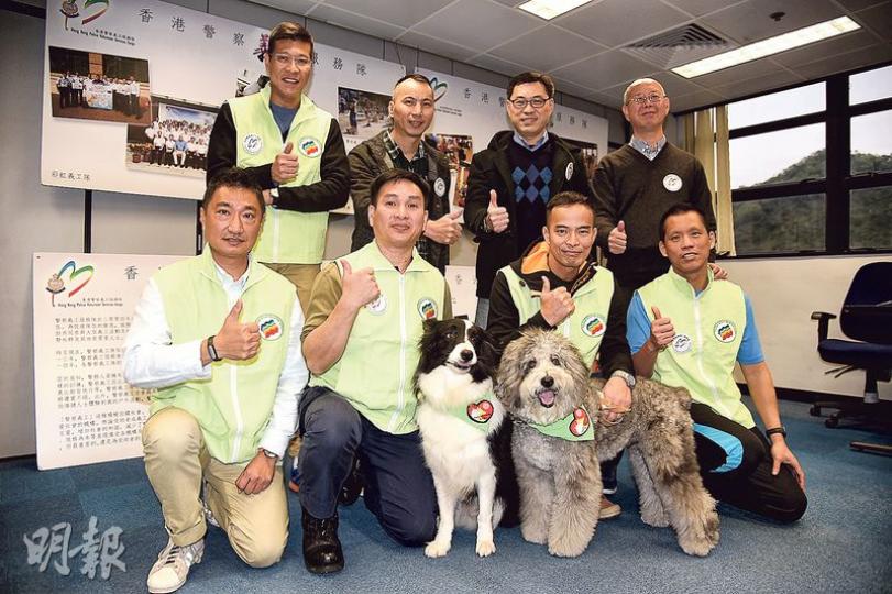 彩虹義工隊成員（黃色背心者）不時會帶同義工犬Eagle（左）及Smartie（右）到學校及社區舉辦活動，令中學生及邊青有機會透過訓練動物，重拾自信及正確價值觀，前右二為陳建國警司，前左二為劉達明警長。（賴俊傑攝）