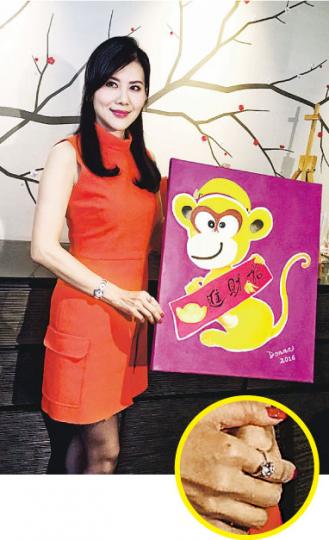 朱潔儀展示其第十二幅生肖油畫《招財金猴》，不過她手上的6卡鑽戒（圓圖）更搶鏡！（攝影：唐嘉晞）