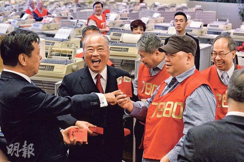 猴年首個交易日，港交所行政總裁李小加（左）向交易員大派利市，主席周松崗（左二）笑不攏嘴。惟恒指昨日大跌742點，是1994年以來最差的農曆年開局。（馮凱鍵攝）