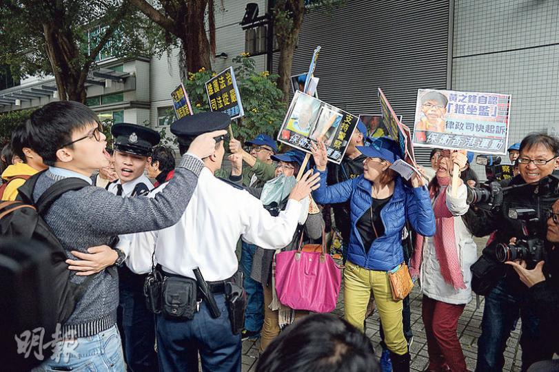 保衛香港運動成員(圖右方)昨在九龍城裁判法院外,與到庭支持林淳軒的學民思潮成員黎汶洛(前左一)等人對罵,警方則站在中間分隔雙方。(鍾林枝攝) 熱血公民成員(靠牆黑衣者)被指在九龍城裁判法院內襲擊兩名保衛香港運動成員,涉嫌普通襲擊被捕,其後被逾10名警員押解上警車離開。(鄧宗弘攝) 保衛香港運動成員(圖右方)昨在九龍城裁判法院外,與到庭支持林淳軒的學民思潮成員黎汶洛(前左一)等人對罵,警方則站在中間分隔雙方。(鍾林枝攝) 熱血公民成員(靠牆黑衣者)被指在九龍城裁判法院內襲擊兩名保衛香港運動成員,涉嫌普通襲擊被捕,其後被逾10名警員押解上警車離開。(鄧宗弘攝)