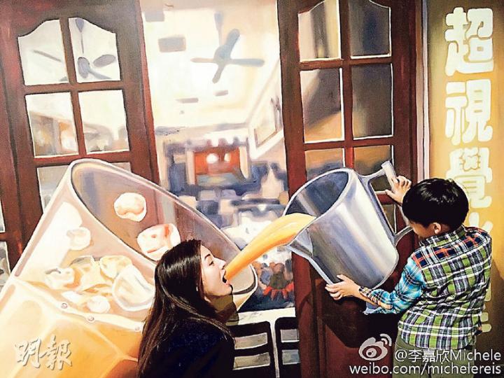 李嘉欣獲兒子Jayden Max作狀拿着巨型杯「餵」她喝「港式奶茶」，她亦張大口配合，場面溫馨搞笑。（微博圖片）