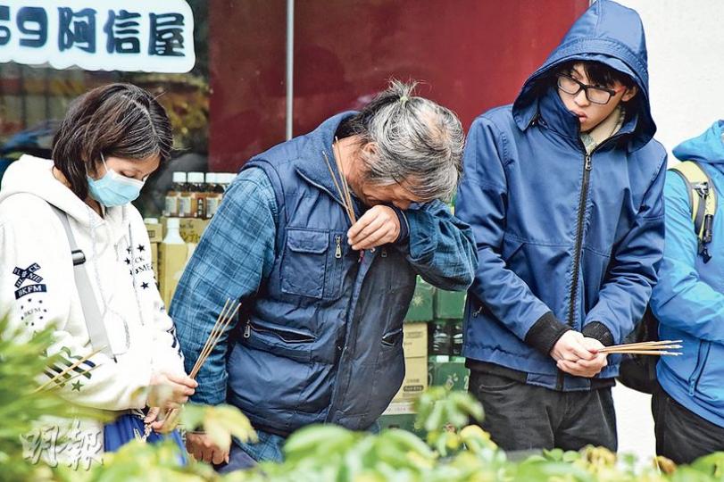 死者母親、父親及胞兄（左起）昨午返回事發現場拜祭，死者父親其間不住飲泣。（林智傑攝）將軍澳昨晨有中五生在長假期後復課日墮樓，送院搶救後不治。仵工其後將遺體舁送殮房。（林智傑攝）