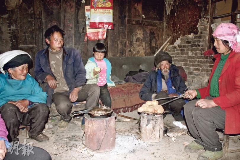 貴州威寧縣貧困戶王友柱（左二）與母親（左一）、父親（右二）、小女兒（中）圍坐在火爐旁，其妻鄧彩彩（右一）則在烤薯仔。（楊立贇攝）