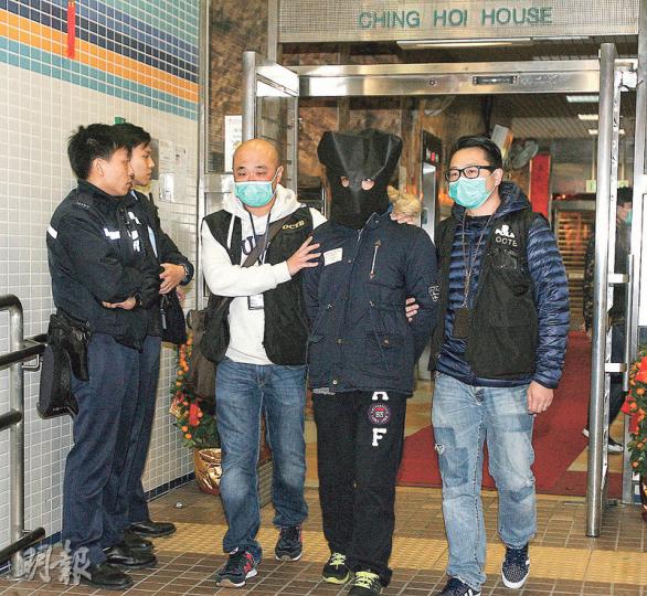 與黃台仰一同被捕的28歲姓張男子（蒙頭者），涉嫌參與暴動及協助罪犯，以及藏有違禁武器及藏有第一部毒藥被捕。（伍浦鋒攝）警方在單位內起獲的證物包括一個「V煞」面具、手套及兩套護甲套件等。（伍浦鋒攝）