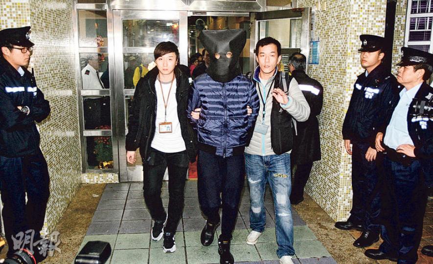前日在天水圍被捕的本土民主前線成員黃台仰（中），昨午被黑布蒙頭及戴上手銬，由探員押返將軍澳彩明苑寓所搜查。（伍浦鋒攝）