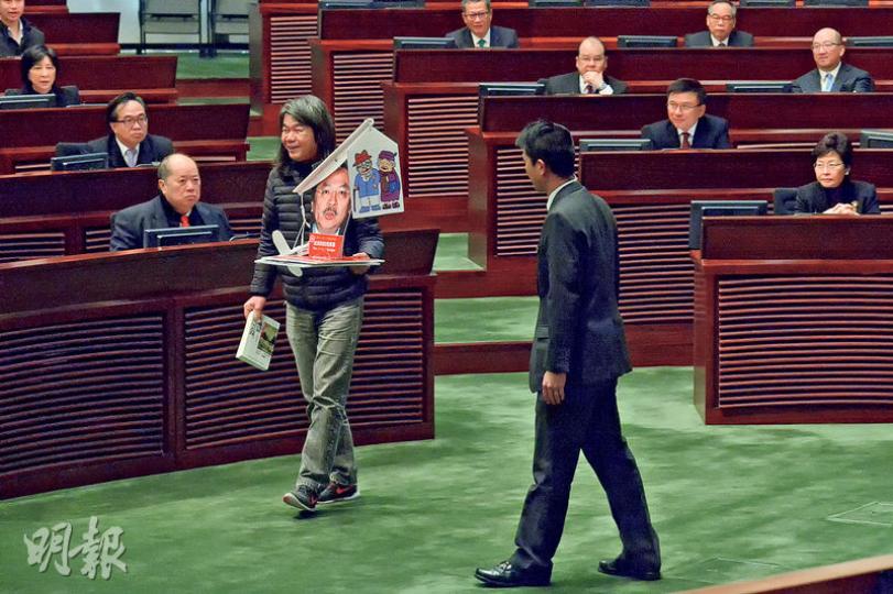 社民連梁國雄(右)拎住一個道具天秤入會議廳,批評預算案只重視三跑等基建,輕視民生。但長毛為咗唔好被主席趕出會議廳,以免影響佢喺之後審議版權條例時拉布,所以無喺財爺宣讀預算案期間激烈示威。(楊柏賢攝) 社民連梁國雄(右)拎住一個道具天秤入會議廳,批評預算案只重視三跑等基建,輕視民生。但長毛為咗唔好被主席趕出會議廳,以免影響佢喺之後審議版權條例時拉布,所以無喺財爺宣讀預算案期間激烈示威。(楊柏賢攝)