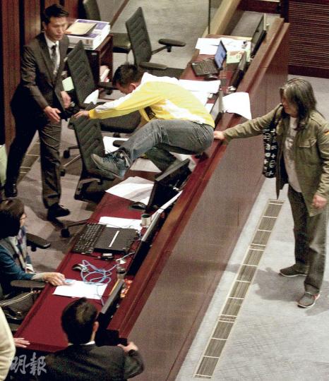 當財委會代主席陳鑑林準備召開第3節會議時,人民力量陳志全跨過主席台坐上主席座位,抗議陳鑑林「剪布」限制每名議員發言兩分鐘。他佔據座位逾半小時後,陳鑑林宣布轉場開會,令該節會議最終延遲50分鐘進入議程,陳志全連同其餘7名抗議的泛民議員,不獲准參與該節會議。(李紹昌攝)昨日是本月最後一次財委會會議,亦到政府須與港鐵考慮高鐵暫時停工之時,有在立會外的反高鐵集會者得悉撥款仍未表決,隨即歡呼。(黃志東攝) 當財委會代主席陳鑑林準備召開第3節會議時,人民力量陳志全跨過主席台坐上主席座位,抗議陳鑑林「剪布」限制每名議員發言兩分鐘。他佔據座位逾半小時後,陳鑑林宣布轉場開會,令該節會議最終延遲50分鐘進入議程,陳志全連同其餘7名抗議的泛民議員,不獲准參與該節會議。(李紹昌攝)昨日是本月最後一次財委會會議,亦到政府須與港鐵考慮高鐵暫時停工之時,有在立會外的反高鐵集會者得悉撥款仍未表決,隨即歡呼。(黃志東攝)