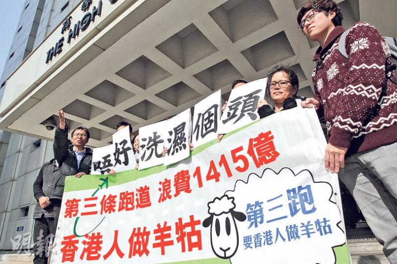 「環保觸覺」成員（圖）在庭外請願，並舉起示威橫額，指三跑日後勢必淪為高鐵「一地兩檢」空中版，要求趁現在「未洗濕個頭」暫停計劃。（郭慶輝攝）