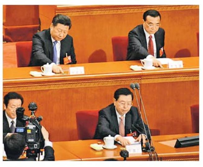全國人大昨日表決多項議案,習近平(後排左)、李克強(後排右)等人按下表決器。(明報記者攝) 全國人大昨日表決多項議案,習近平(後排左)、李克強(後排右)等人按下表決器。(明報記者攝)