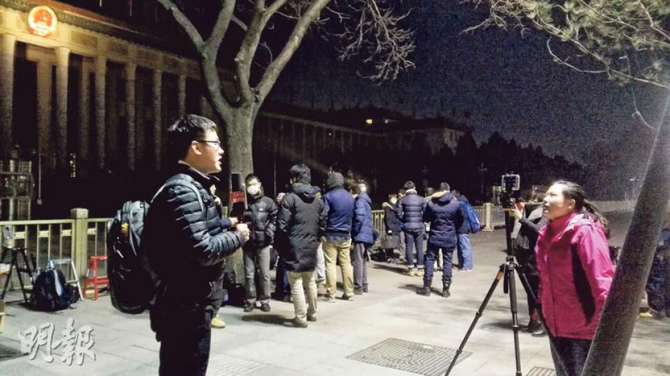 天還沒亮,許多記者就在大會堂廣場前排隊,等候進入總理記者會會場。(明報記者攝) 天還沒亮,許多記者就在大會堂廣場前排隊,等候進入總理記者會會場。(明報記者攝)
