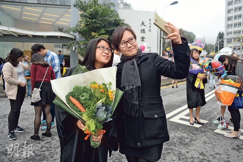 今個學年畢業的中大學生Karis（左）昨獲同學Manessa（右）送贈時蔬花束，不忘合照留念。Manessa認為，時蔬花束構思有趣及具意思。（鍾林枝攝）