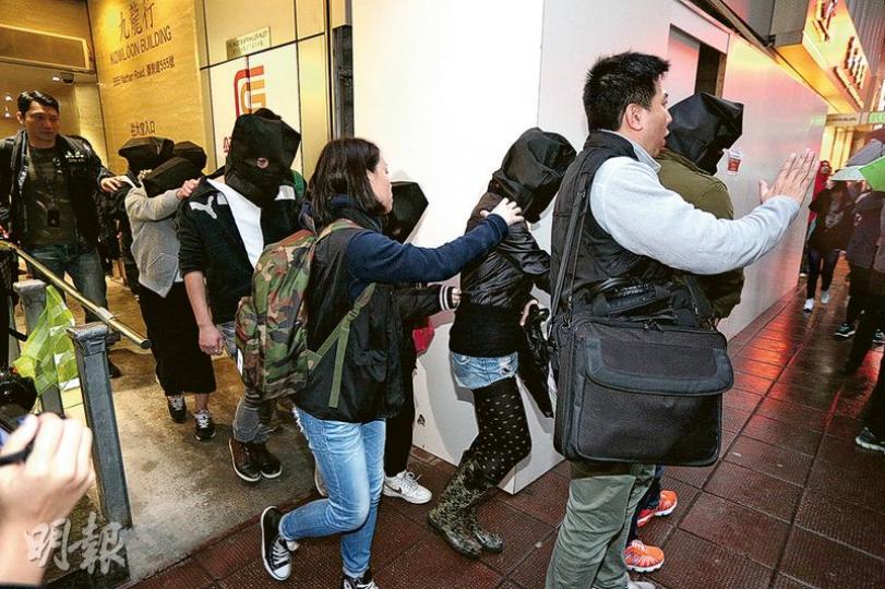 警方昨突擊搜查西九龍區5間財務中介公司,拘捕41人,全部涉嫌串謀詐騙帶署扣查。圖為在旺角彌敦道555號一間中介公司被捕的疑犯。(伍浦鋒攝) 警方昨突擊搜查西九龍區5間財務中介公司,拘捕41人,全部涉嫌串謀詐騙帶署扣查。圖為在旺角彌敦道555號一間中介公司被捕的疑犯。(伍浦鋒攝)