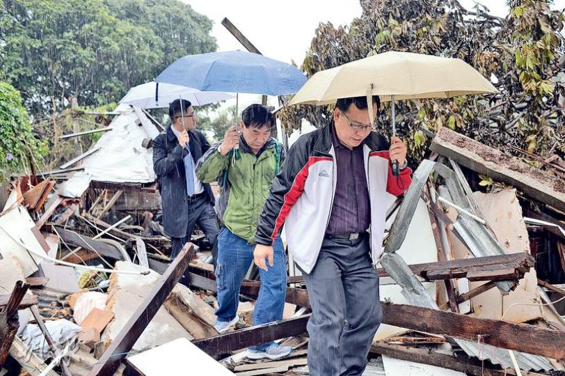 受強拆影響的古洞居民黃文化(中)在民主黨總幹事林卓廷(後)陪同下,昨與地政總署寮屋管制辦事處助理經理林廣輝(前)等人察看其住所被毁情况。當時大雨滂沱,被夷平的房屋更見破落,黃文化黯然神傷,強調即使違法仍會堅持原址重建。(馮凱鍵攝) 受強拆影響的古洞居民黃文化(中)在民主黨總幹事林卓廷(後)陪同下,昨與地政總署寮屋管制辦事處助理經理林廣輝(前)等人察看其住所被毁情况。當時大雨滂沱,被夷平的房屋更見破落,黃文化黯然神傷,強調即使違法仍會堅持原址重建。(馮凱鍵攝)