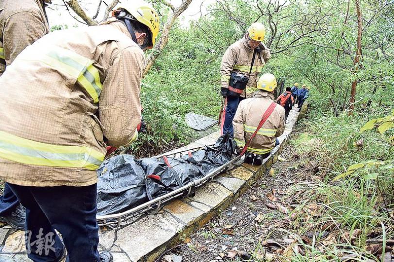 4名消防員合力將死者遺體抬落山腳位置,交由仵工舁送殮房。(林智傑攝) 4名消防員合力將死者遺體抬落山腳位置,交由仵工舁送殮房。(林智傑攝)