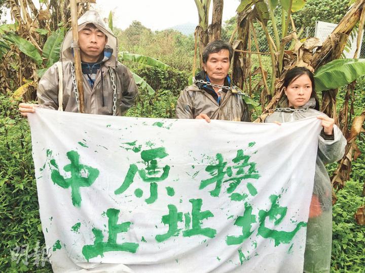 恒基近日收回粉嶺一幅7000平方呎的農地,工人昨午欲以鐵絲網圍起收地範圍,被村民阻止。村民區流根(中)及馬寶寶社區農場數名成員以鐵鏈及鎖把自己綁在蕉樹旁,並拉起橫額反對收地,促請當局中止原址換地政策。(賴嘉梨攝)昨日有聲稱恒基派來的工人到場,計劃用鐵絲網圍起收地範圍,在村民抗議下離開,遺下一批築圍網材料。(賴嘉梨攝) 恒基近日收回粉嶺一幅7000平方呎的農地,工人昨午欲以鐵絲網圍起收地範圍,被村民阻止。村民區流根(中)及馬寶寶社區農場數名成員以鐵鏈及鎖把自己綁在蕉樹旁,並拉起橫額反對收地,促請當局中止原址換地政策。(賴嘉梨攝)昨日有聲稱恒基派來的工人到場,計劃用鐵絲網圍起收地範圍,在村民抗議下離開,遺下一批築圍網材料。(賴嘉梨攝)