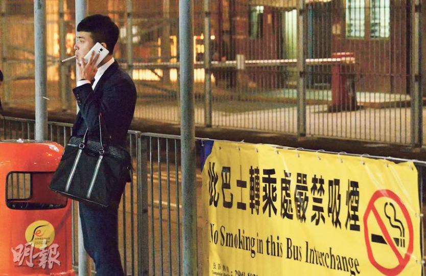 本港8個隧道口巴士轉乘處昨日起禁煙,本報記者昨早發現,不少人在紅磡海底隧道口的巴士轉乘處禁煙區吸煙。至昨晚7時許,仍有市民在禁煙橫額前如常吸煙(圖)。(馮凱鍵攝) 本港8個隧道口巴士轉乘處昨日起禁煙,本報記者昨早發現,不少人在紅磡海底隧道口的巴士轉乘處禁煙區吸煙。至昨晚7時許,仍有市民在禁煙橫額前如常吸煙(圖)。(馮凱鍵攝)