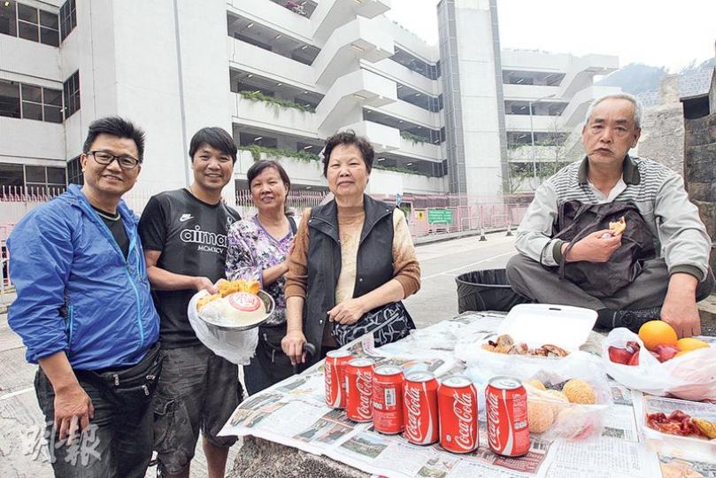 陳女士（左三）和家人帶同燒鴨和水果等到將軍澳華人永遠墳場拜祭先人，她說祭品價格較往年貴兩至三成，合共花約1000元購買。（李紹昌攝）