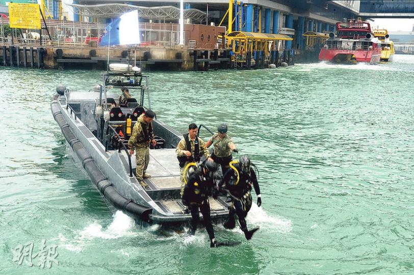 警方飛虎隊「水鬼隊」蛙人落海打撈兇刀。（衛永康攝）「水鬼隊」蛙人在海底尋獲涉案開山刀。（衛永康攝）其中一名疑犯被押到中區警署外重組案情。（衛永康攝）
