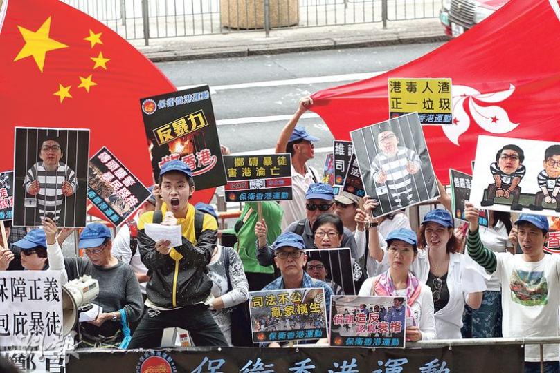 昨日開庭前，「保衛香港運動」和「珍惜群組」共約30人在法院門外示威，高呼「嚴懲暴徒，入獄找數」等口號。（李紹昌攝）被控暴動罪的本土民主前線發言人梁天琦昨提堂，案件押後至5月10日再訊，等待警方調查及法律意見。對於一眾被告的住址被傳媒公開，梁在庭外批評是「不知所謂」。（李紹昌攝）