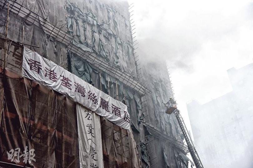 火警期間,改建中的大廈多個樓層不斷冒出濃煙,直冲半空,遠近皆見。(蔡方山攝) 火警期間,改建中的大廈多個樓層不斷冒出濃煙,直冲半空,遠近皆見。(蔡方山攝)