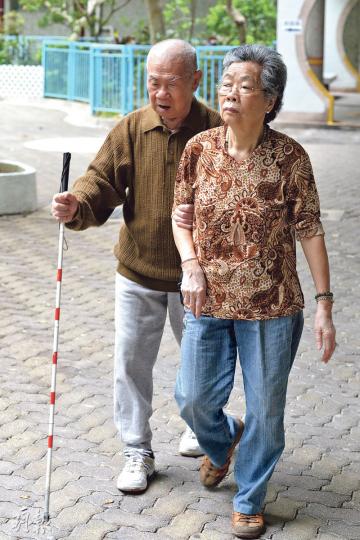 87歲的張木才（左）與太太居於華貴邨華賢樓，他說因害怕跌倒，出入都依賴太太帶路。（楊柏賢攝）