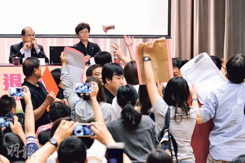政務司長林鄭月娥(後排右)及勞福局長張建宗(後排左)昨出席退保諮詢會期間,有示威者走到台前撒溪錢,幾乎擲中林太,工作人員即上前阻止,場面一度混亂。(楊柏賢攝) 政務司長林鄭月娥(後排右)及勞福局長張建宗(後排左)昨出席退保諮詢會期間,有示威者走到台前撒溪錢,幾乎擲中林太,工作人員即上前阻止,場面一度混亂。(楊柏賢攝)