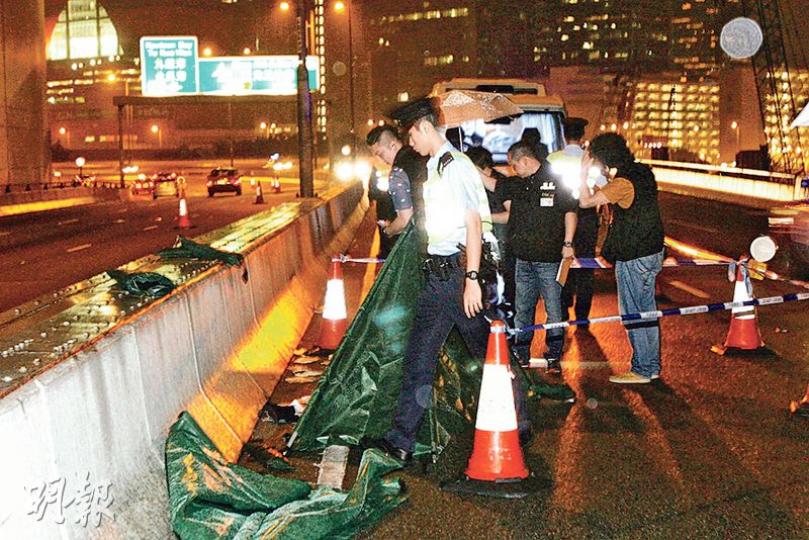 觀塘繞道黑幫尋仇血案,警員到場調查時,因大雨需以帳篷將證物遮蓋,以免影響蒐證。(伍浦鋒攝) 觀塘繞道黑幫尋仇血案,警員到場調查時,因大雨需以帳篷將證物遮蓋,以免影響蒐證。(伍浦鋒攝)