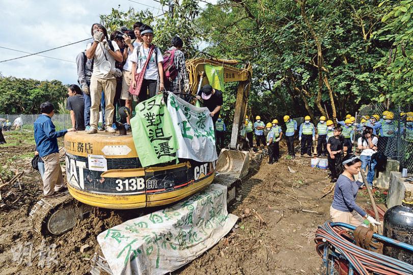 雙方對峙期間,有10多名抗議者順利突破人牆進入工地,爬上挖泥車拉起「反對迫遷」、「保衛東北」及「城鄉共生」等橫額,不斷叫口號。(楊柏賢攝)恒基地產在昨日收地行動中,出動逾70名保安員築起人牆,並把示威者強行拉扯抬到工地外行人路邊。(楊柏賢攝) 雙方對峙期間,有10多名抗議者順利突破人牆進入工地,爬上挖泥車拉起「反對迫遷」、「保衛東北」及「城鄉共生」等橫額,不斷叫口號。(楊柏賢攝)恒基地產在昨日收地行動中,出動逾70名保安員築起人牆,並把示威者強行拉扯抬到工地外行人路邊。(楊柏賢攝)